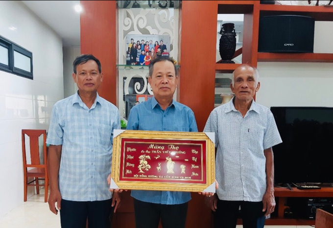 Đại diện ban liên lạc hội đồng hương xã Cẩm Bình tại TP. HCM trao tặng khánh chúc mừng cho các cụ từ 70 tuổi trở lên