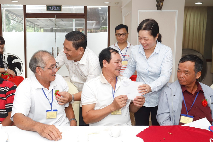 Giám đốc Sở LĐTB&XH Lý Văn Cẩm và Phó GĐ Sở LĐTB&XH Nguyễn Thị Kiều Loan tặng tiền và cài hoa cho NCC