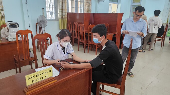 Cán bộ Trung tâm y tế huyện Vĩnh Cửu đo mắt và huyết áp cho công dân