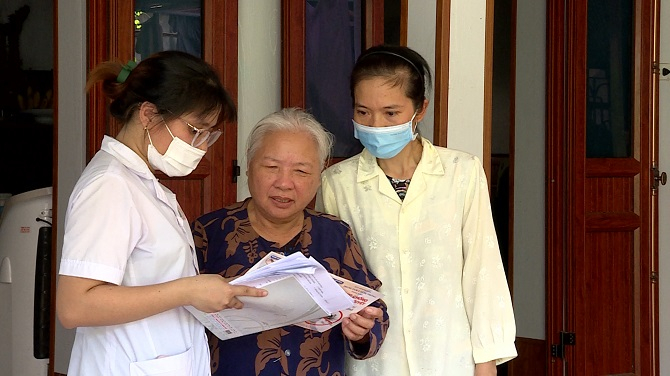 Cán bộ y tế phát tờ rơi tuyên truyền các biện pháp phòng chống sốt xuất huyết cho người dân