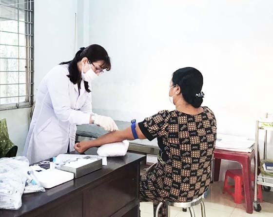Cán bộ điều tra lấy mẫu xét nghiệm cho người dân tại xã