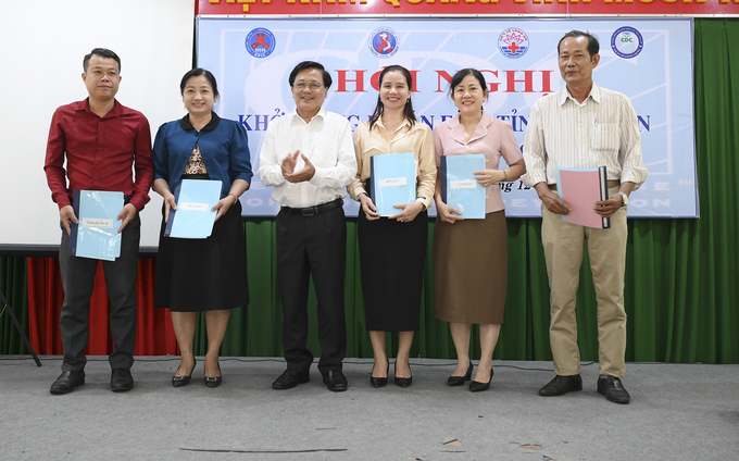 Phó Giám đốc Sở Y tế bác sĩ Bùi Quốc Dũng (thứ 3 từ trái sang) trao hợp đồng trách nhiệm cho các huyện thụ hưởng dự án