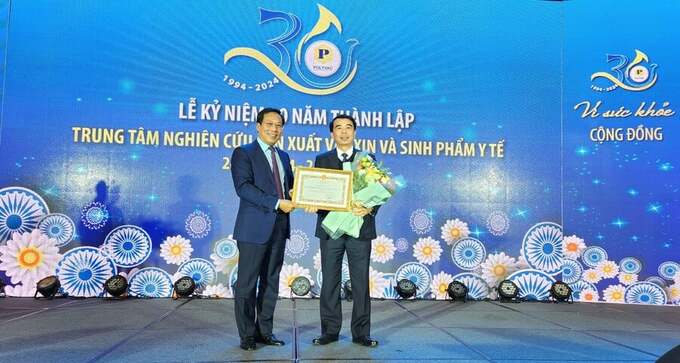 Thứ trưởng Bộ Y tế Lê Đức Luận trao Bằng khen của Bộ trưởng Bộ Y tế cho tập thể Trung tâm Nghiên cứu sản xuất vắc xin và sinh phẩm y tế