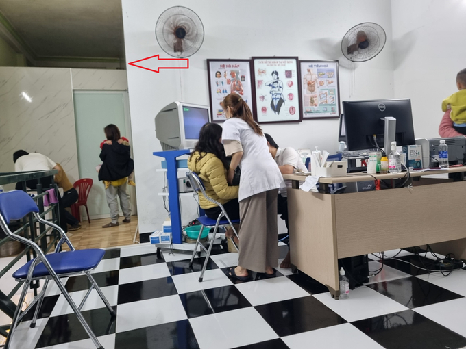 Bên trên tầng 2 là khu vực khám bệnh, người được cho là bác sĩ phụ trách phòng khám Đàm Đại Tá đang khám cho bệnh nhi 