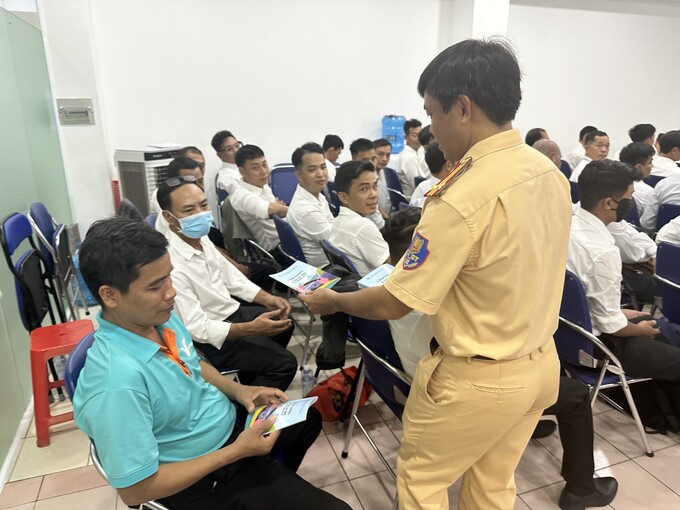 Cán bộ Phòng CSGT phát Cẩm nang và tờ rơi tuyên truyền ATGT cho lái xe tham dự tập huấn