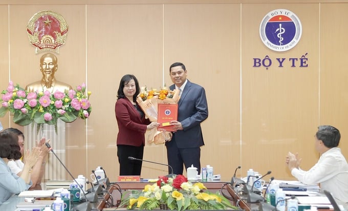 Bộ trưởng Bộ Y tế Đào Hồng Lan trao quyết định bổ nhiệm Phó Vụ trưởng Vụ Bảo hiểm Y tế cho ông Hoàng Trung Tuấn (Ảnh: Trần Minh)