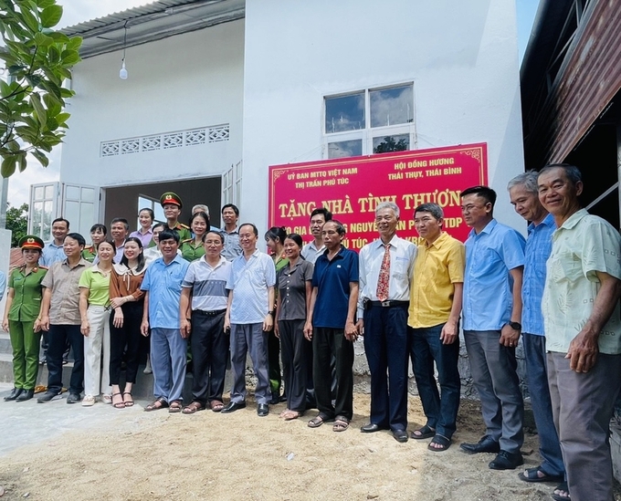 Ban Tổ chức bàn giao nhà tình nghĩa cho gia đình ông Nguyễn Văn Phong (thứ 6 từ phải sang, tổ dân phố 10, thị trấn Phú Túc (Ảnh: Vũ Chi)