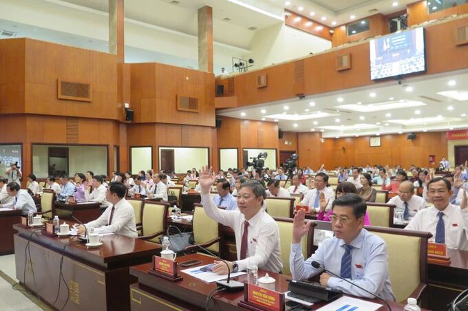 Các đại biểu biểu quyết thông qua Nghị quyết quy định chính sách đặc thù hỗ trợ học phí cho học sinh THCS công lập, ngoài công lập và học viên giáo dục thường xuyên THCS trên địa bàn thành phố năm học 2024 - 2025