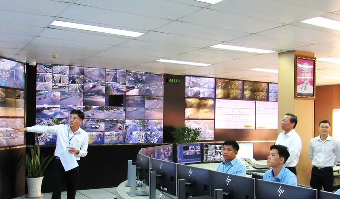 Chủ tịch UBND TP. HCM Phan Văn Mãi nghe ông Đoàn Văn Tấn - Giám đốc Trung tâm Quản lý điều hành giao thông đô thị, giới thiệu hệ thống camera giám sát giao thông trên địa bàn Thành phố