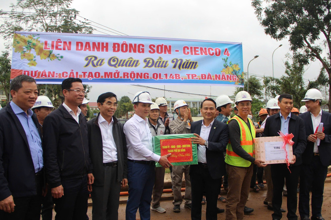 Phó Bí thư Thường trực Thành uỷ Nguyễn Đình Vĩnh và Phó Chủ tịch Thường trực UBND thành phố Hồ Kỳ Minh tặng quà động viên đơn vị thi công dự án cải tạo, nâng cấp quốc lộ 14B
