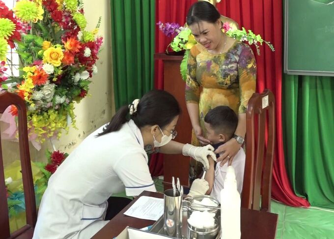 Nhân viên Trạm Y tế Mong Thọ, huyện Châu Thành tiêm ngừa sởi cho học sinh trường Tiểu học Mong Thọ 2 (Ảnh Huỳnh Tâm)