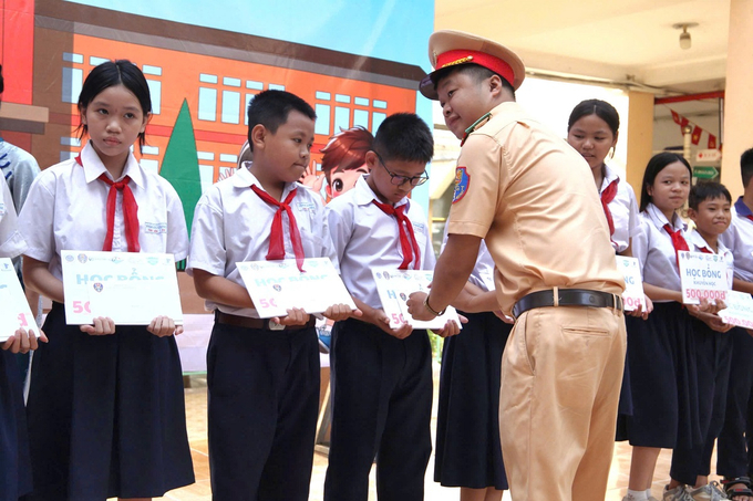 Đại úy Trịnh Trung Hiếu - Bí thư Chi đoàn Thanh niên phía Nam Cục CSGT trao học bổng cho học sinh