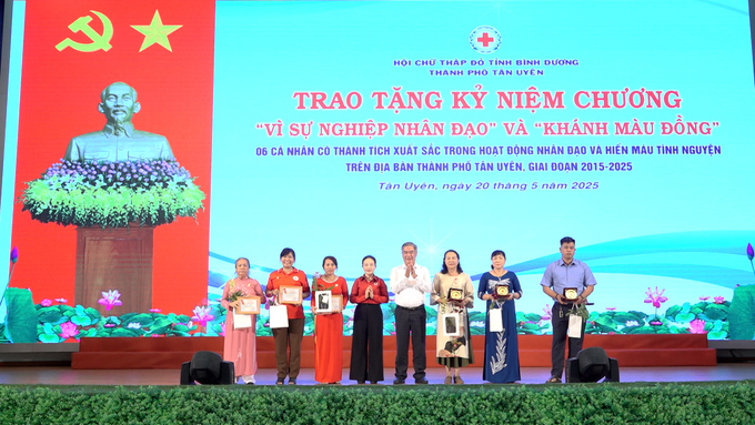 Đại diện lãnh đạo trao  “Khánh màu đồng” của Ban chỉ đạo vận động HMTN Quốc gia cho 3 gia đình HMTN 50, 60 lần