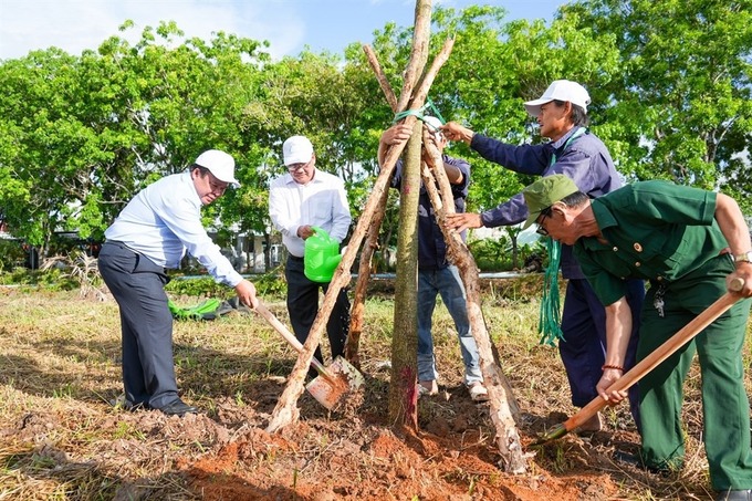Phó Chủ tịch UBND tỉnh Nguyễn Minh Luân (bìa trái) tham gia trồng cây bảo vệ môi trường, chống biến đổi khí hậu
