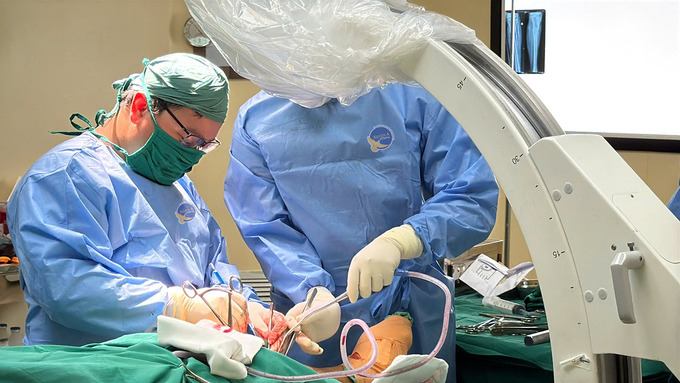 Ekip phẫu thuật dưới hướng dẫn của hệ thống màn hình tăng sáng (C-arm) (Ảnh: BVCC)