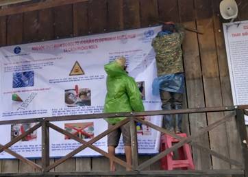 Các đoàn thể thôn, làng phối hợp với lực lượng y tế xã treo áp phích truyên truyền tại các nhà Rông của các điểm sinh hoạt cộng đồng