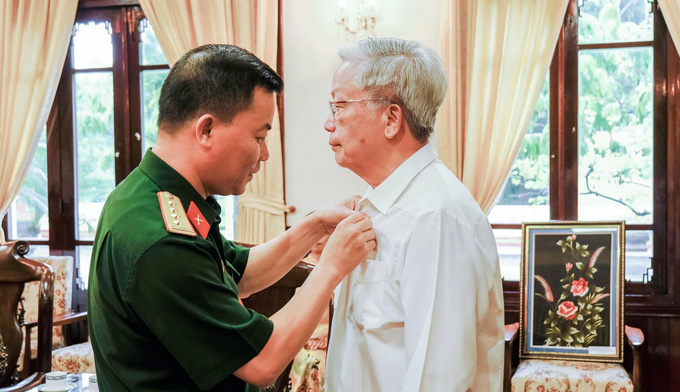 Đại tá Đỗ Hoàng Việt – Phó Chính ủy Bộ Tư lệnh Lăng trao Huy hiệu Bác Hồ cho các thành viên đoàn Hội VACHE  