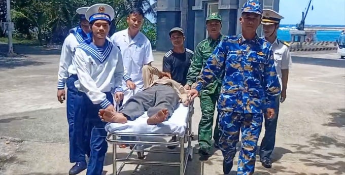 Cán bộ, chiến sĩ đảo Trường Sa đưa ngư dân Nguyễn Văn Lai lên đảo cấp cứu (Ảnh: PV)
