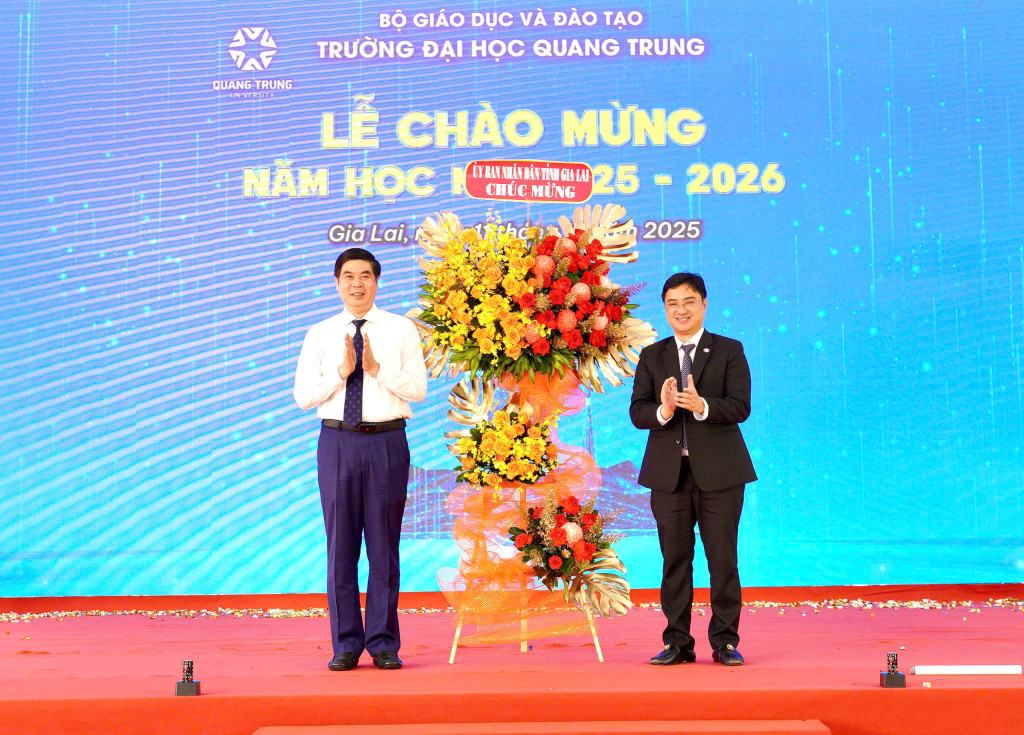Ông Lâm Hải Giang - Phó Chủ tịch UBND tỉnh Gia Lai (trái) tặng hoa chúc mừng Trường Đại học Quang Trung tại Lễ chào mừng năm học mới