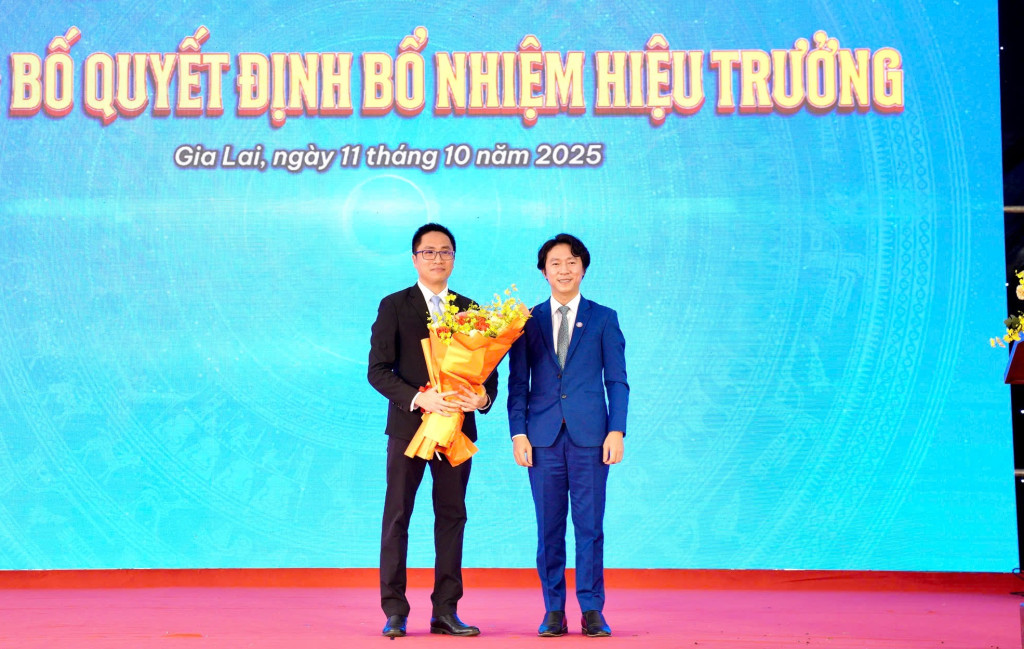 Đại diện Hội đồng Trường Đại học Quang Trung tặng hoa chúc mừng tiến sĩ Tô Bá Lâm (trái) giữ chức Hiệu trưởng nhà trường