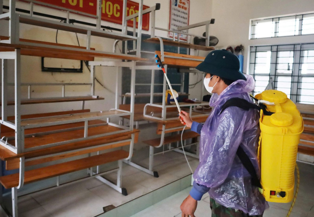 Lực lượng y tế phun hóa chất khử khuẩn bằng Cloramin B tại trường THCS Cẩm Duệ.
