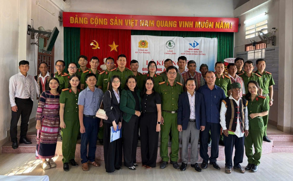 Đại diện Công ty Đấu giá hợp danh Đông Dương, Công an xã Tuy Phước và bà con làng Canh Lãnh chụp ảnh lưu niệm