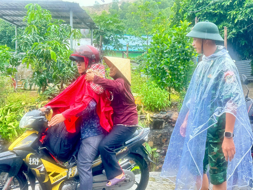 Cán bộ, chiến sĩ hỗ trợ đưa người già về nhà văn hóa để trú bão (Ảnh:Thanh Huy)